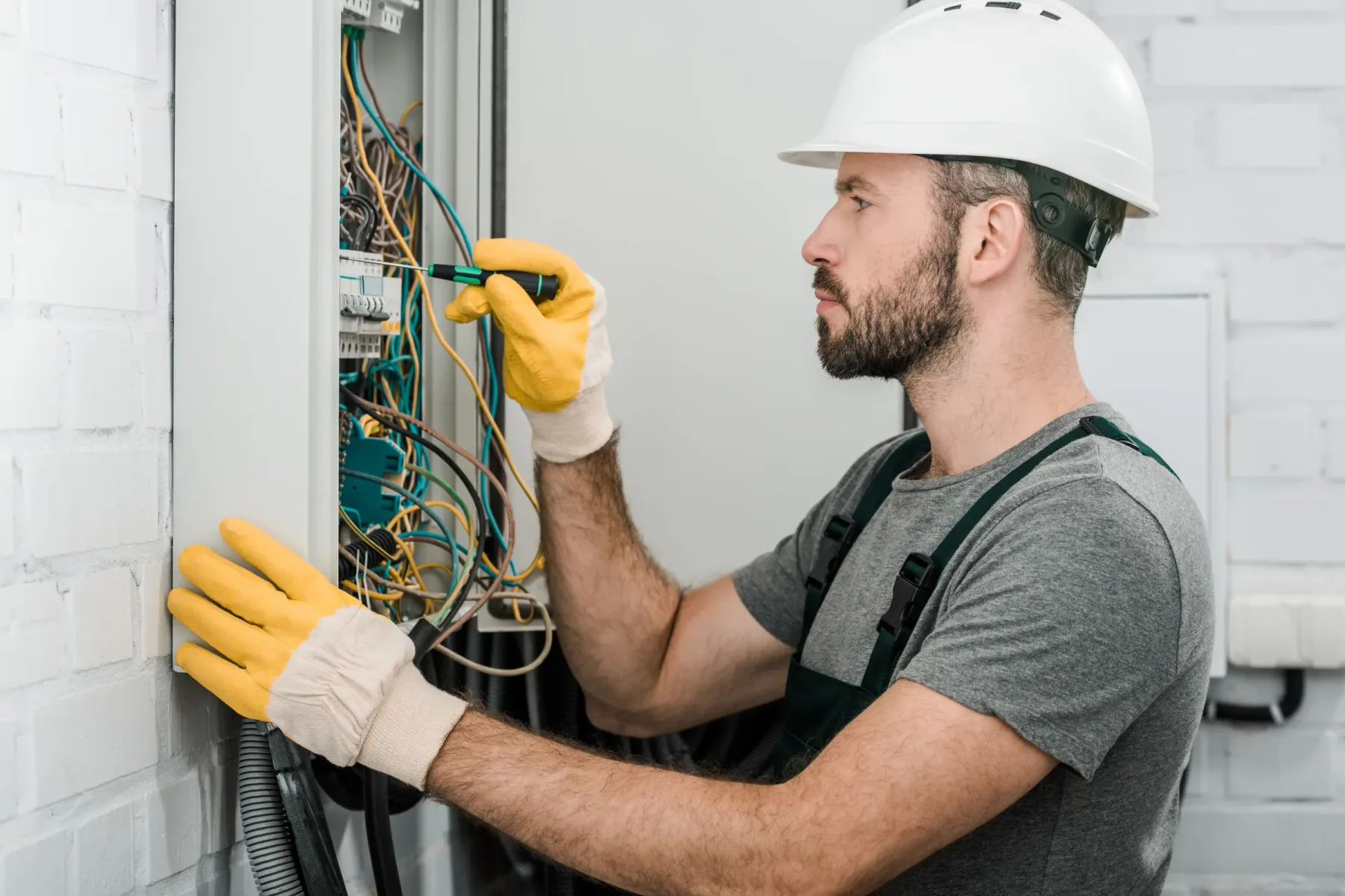 Electrical wiring work at a commercial electrical panel.